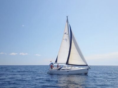 Velero navegando a vela en mar abierto frente a la costa de Barcelona
